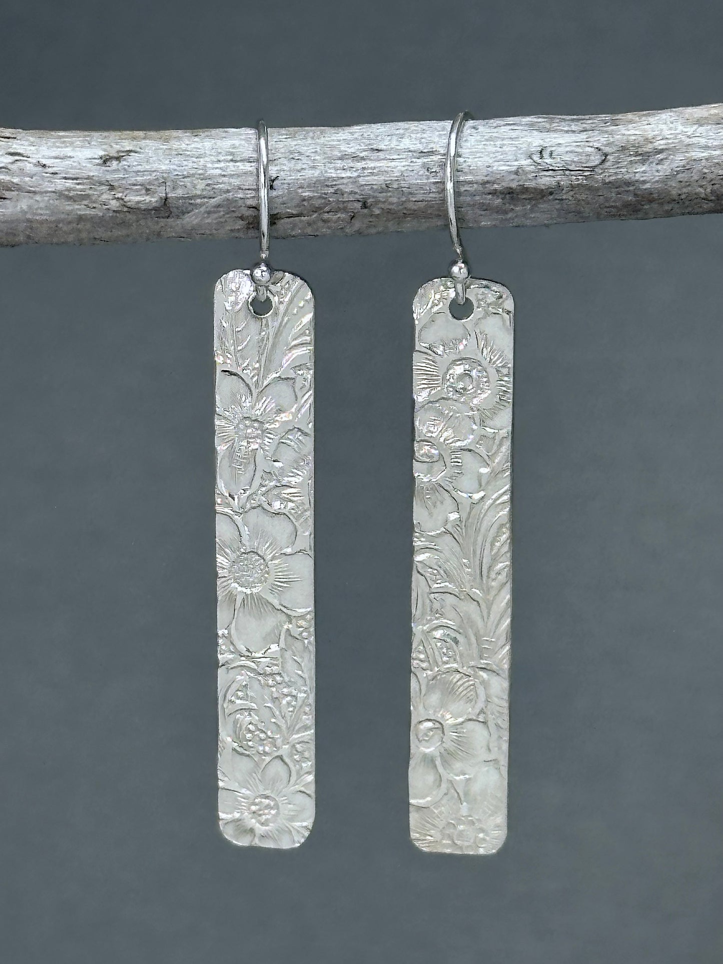 14kt gold filled or sterling bar dangle earrings with a 1/4" wide x 1.5" long bar with an embossed vintage floral pattern, hangs from standard ear wires or lever back hooks. hand crafted artisan jewelry by hanni jewelry, harbor springs, michigan.