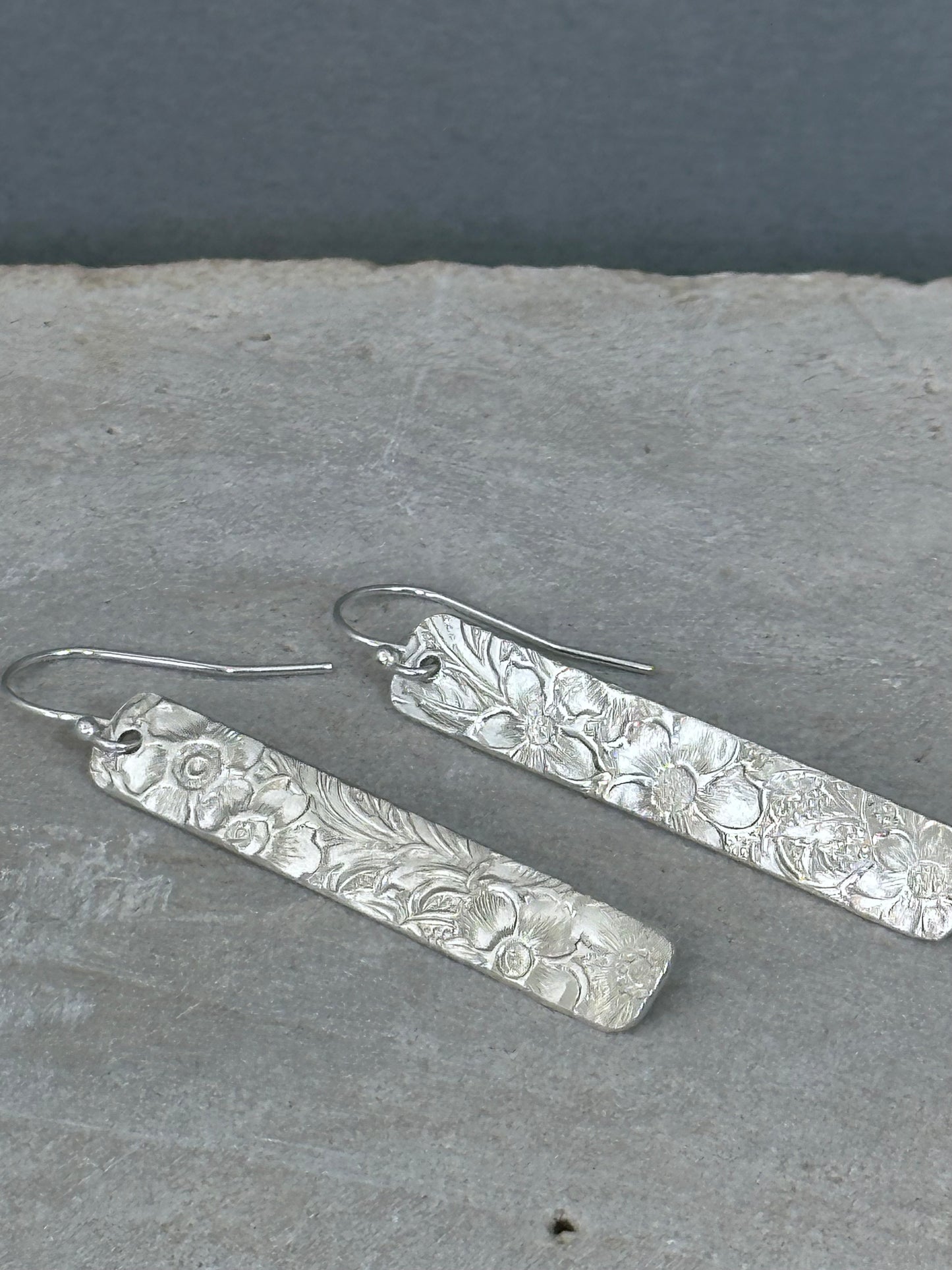 14kt gold filled or sterling bar dangle earrings with a 1/4" wide x 1.5" long bar with an embossed vintage floral pattern, hangs from standard ear wires or lever back hooks. hand crafted artisan jewelry by hanni jewelry, harbor springs, michigan.