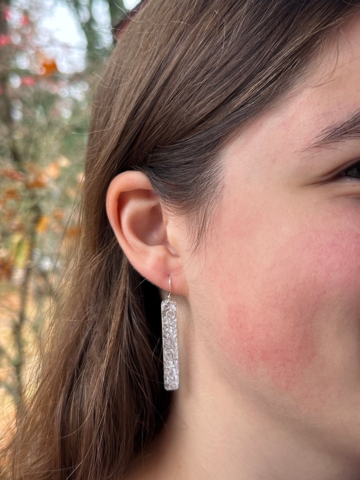 14kt gold filled or sterling bar dangle earrings with a 1/4" wide x 1.5" long bar with an embossed vintage floral pattern, hangs from standard ear wires or lever back hooks. hand crafted artisan jewelry by hanni jewelry, harbor springs, michigan.
