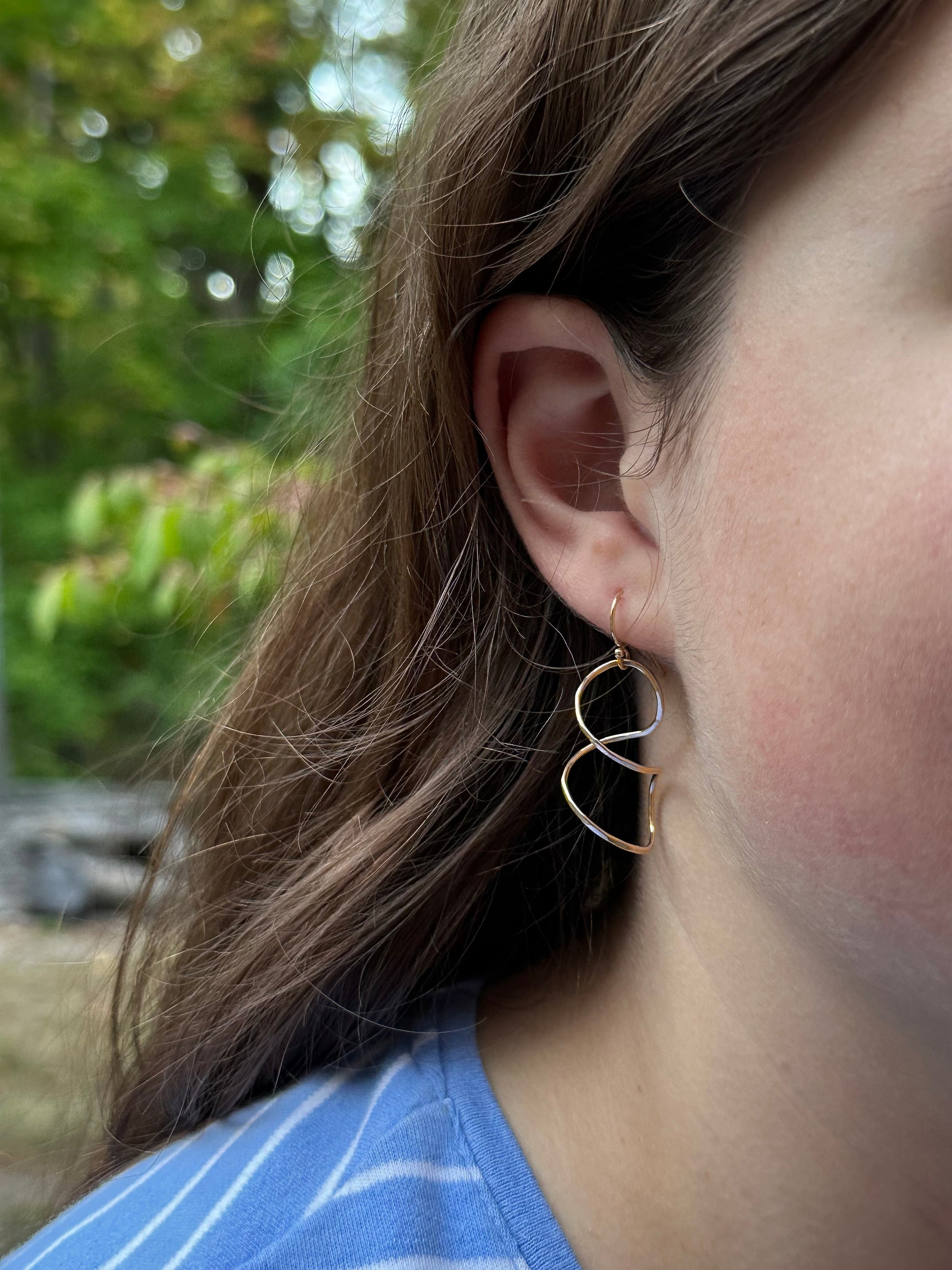 Twisty spiral wire earring on model  in sterling silver or 14kt gold filled, Simple modern dangle in four sizes 1 to 2 inches long, available on french hook or leverback ear wires, artist handmade by hanni jewelry in harbor springs, michigan