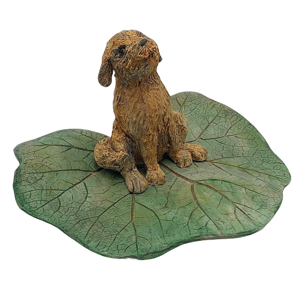 Ceramic sculpture, shaggy dog sitting on leaf, happy expression, northern michigan artist, hanni gallery, harbor springs